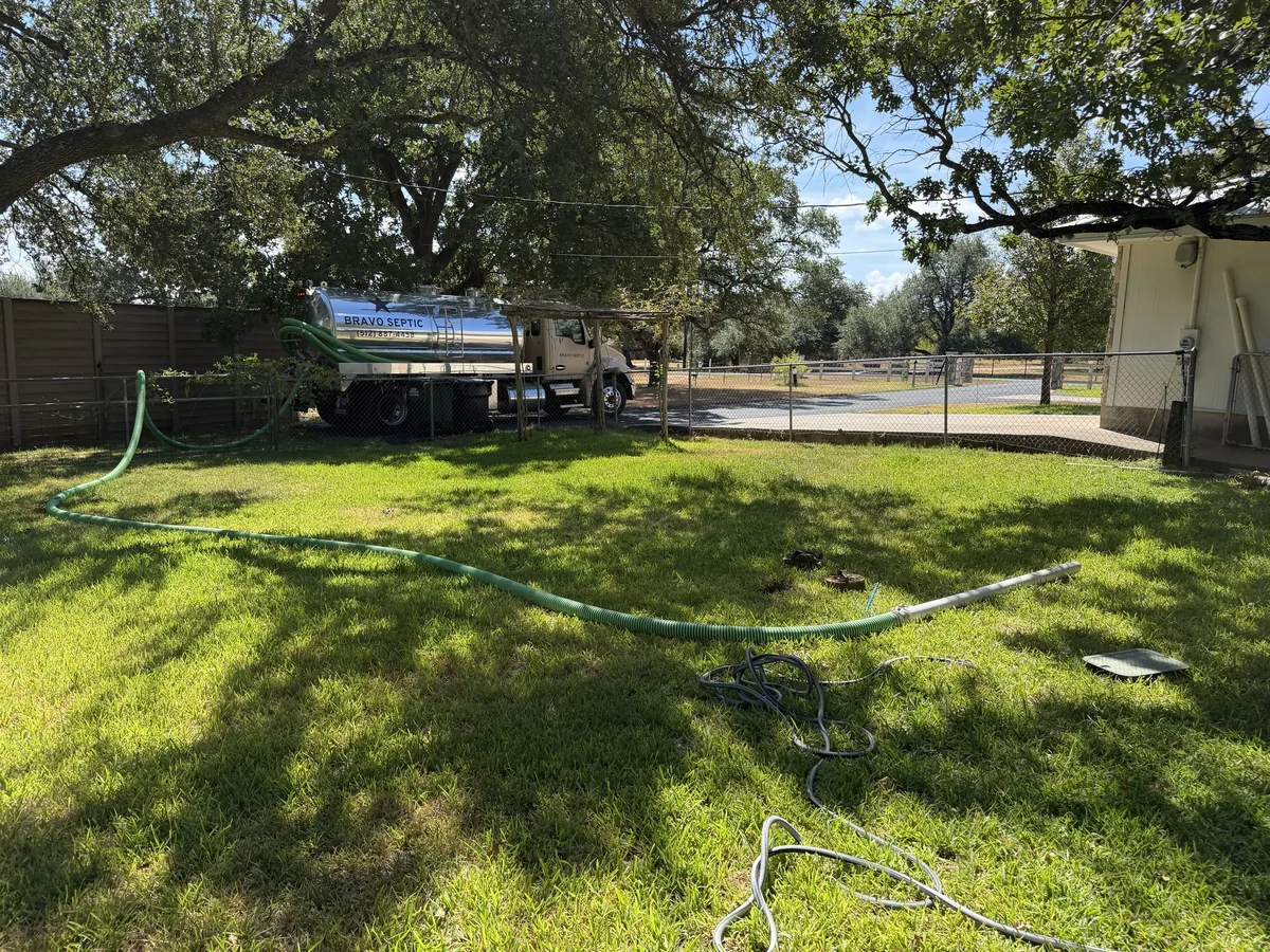 The suction hose run across a back yard from the Bravo Septic pump truck to the septic tank