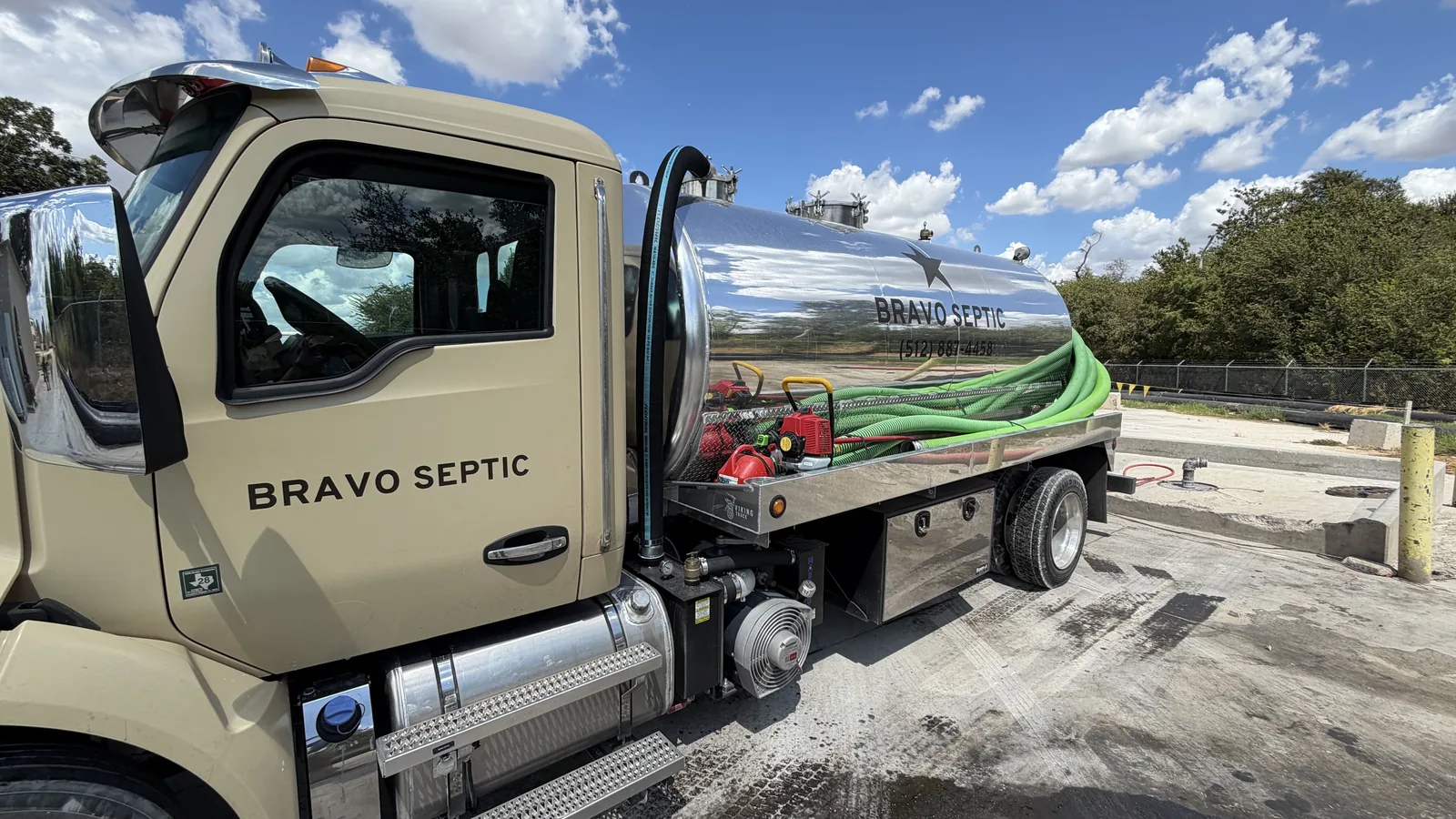 The Bravo Septic pump truck with its hose reel and lettered stainless tank