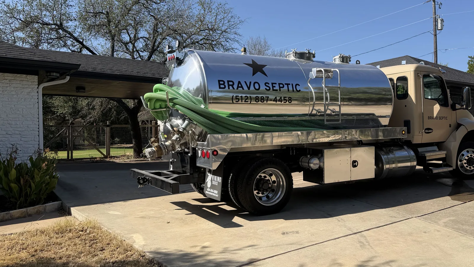 The Bravo Septic pump truck parked on a driveway with the suction hose run out