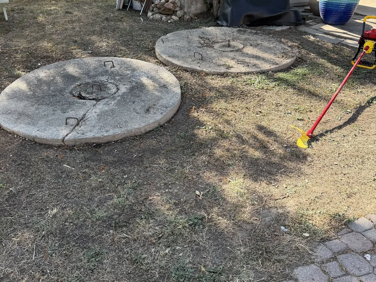 Old concrete septic tank lids uncovered in the ground